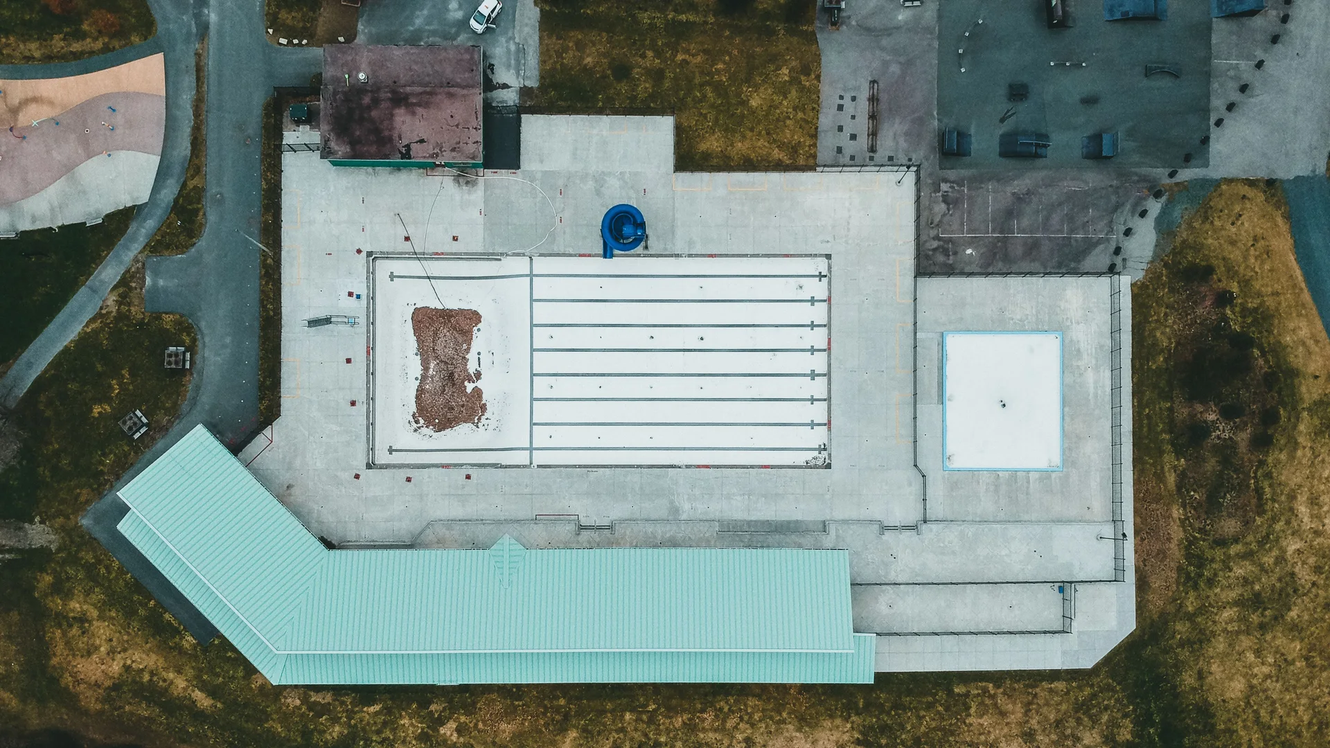 Aerial view of a large low-slope commercial roof with varied membrane and surface areas