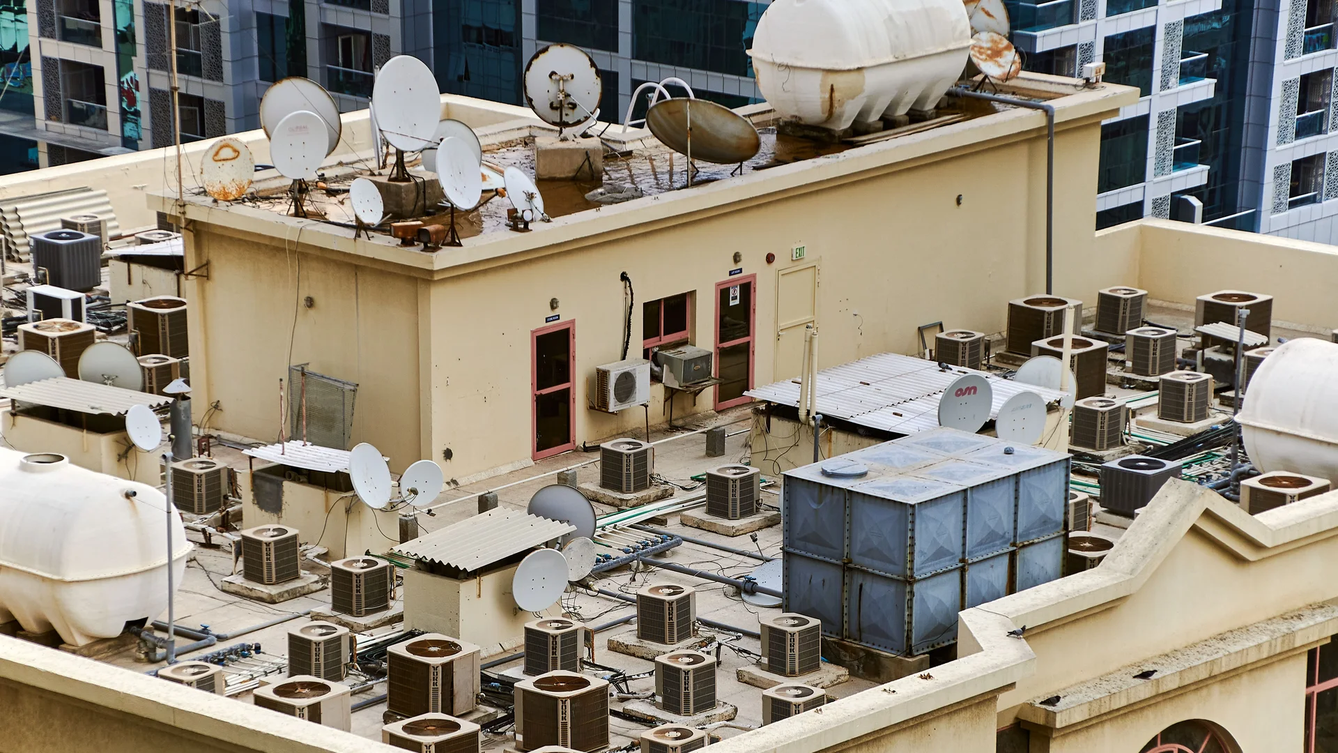 Commercial low-slope rooftops enclosed by parapet walls and coping