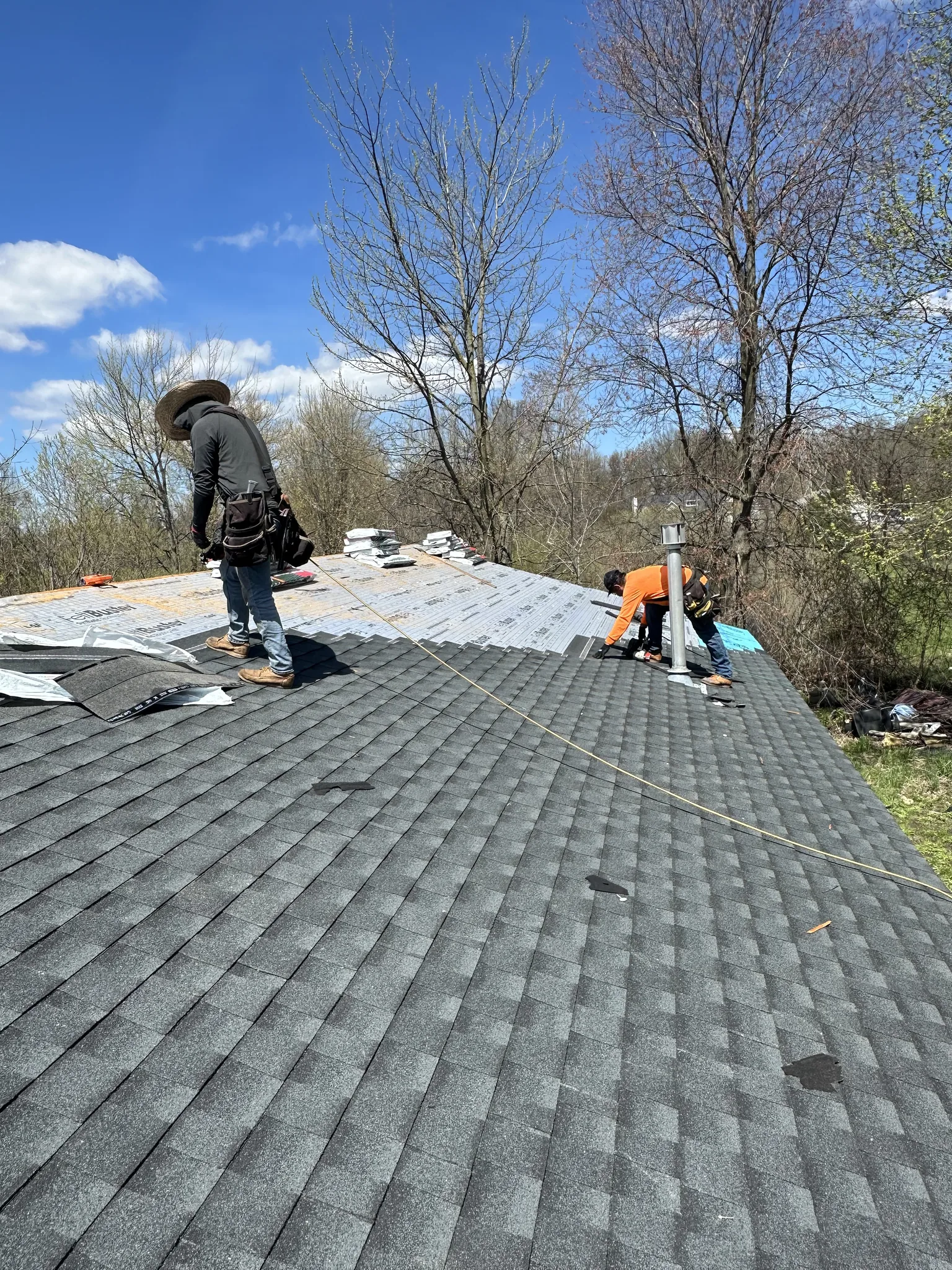 Platinum Roofing crew installing asphalt shingles over fresh underlayment after the old roof covering was removed