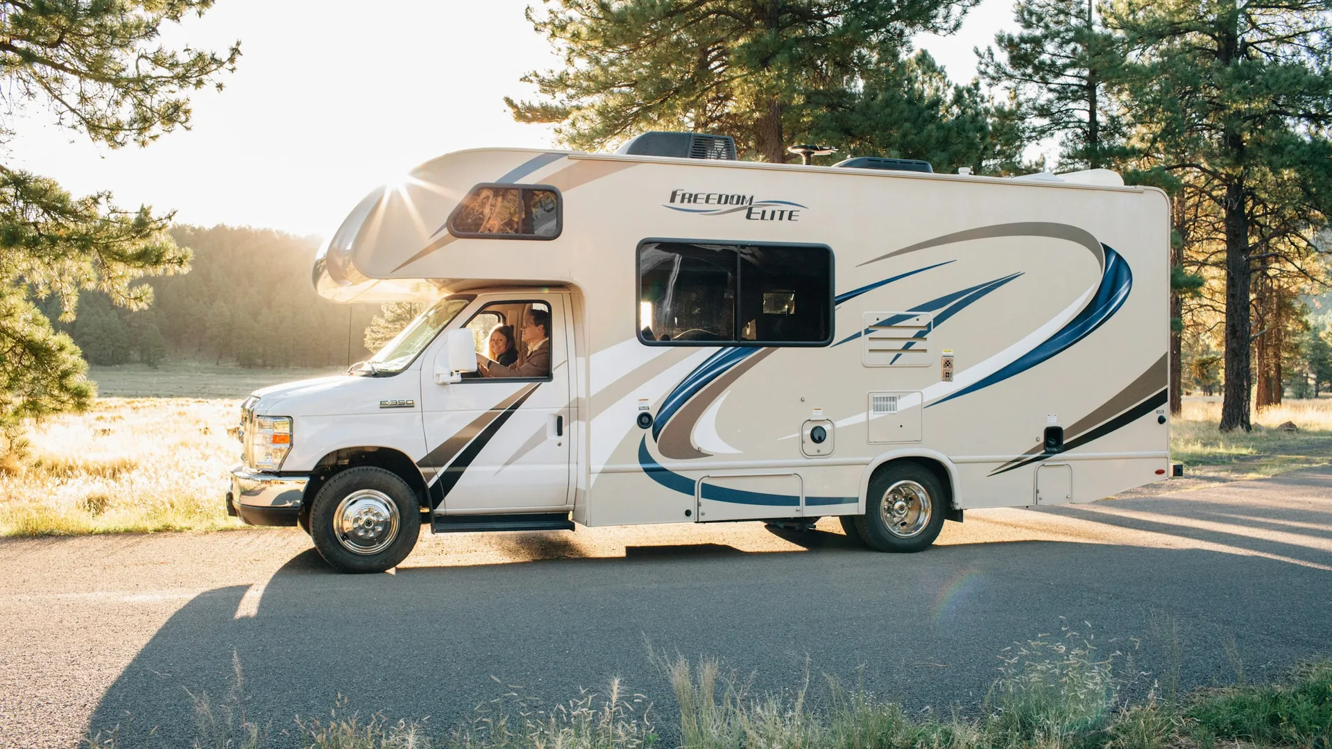 Class C motorhome with rooftop air-conditioning units and other roof components visible