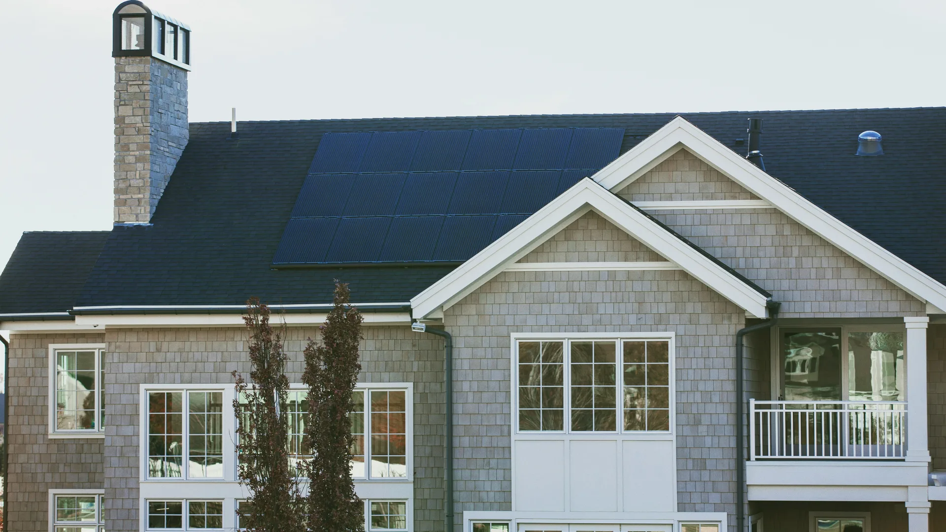 Solar panels mounted on an asphalt shingle roof with exposed roofing visible around the array