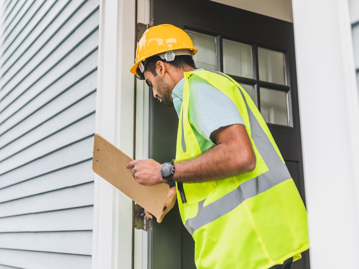 Professional roof inspector examining residential property