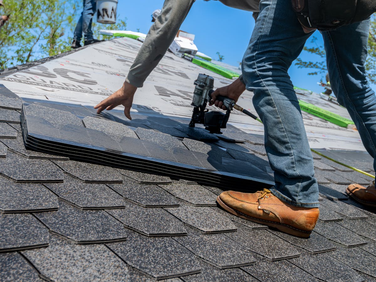 Roofer installing shingles on residential roof