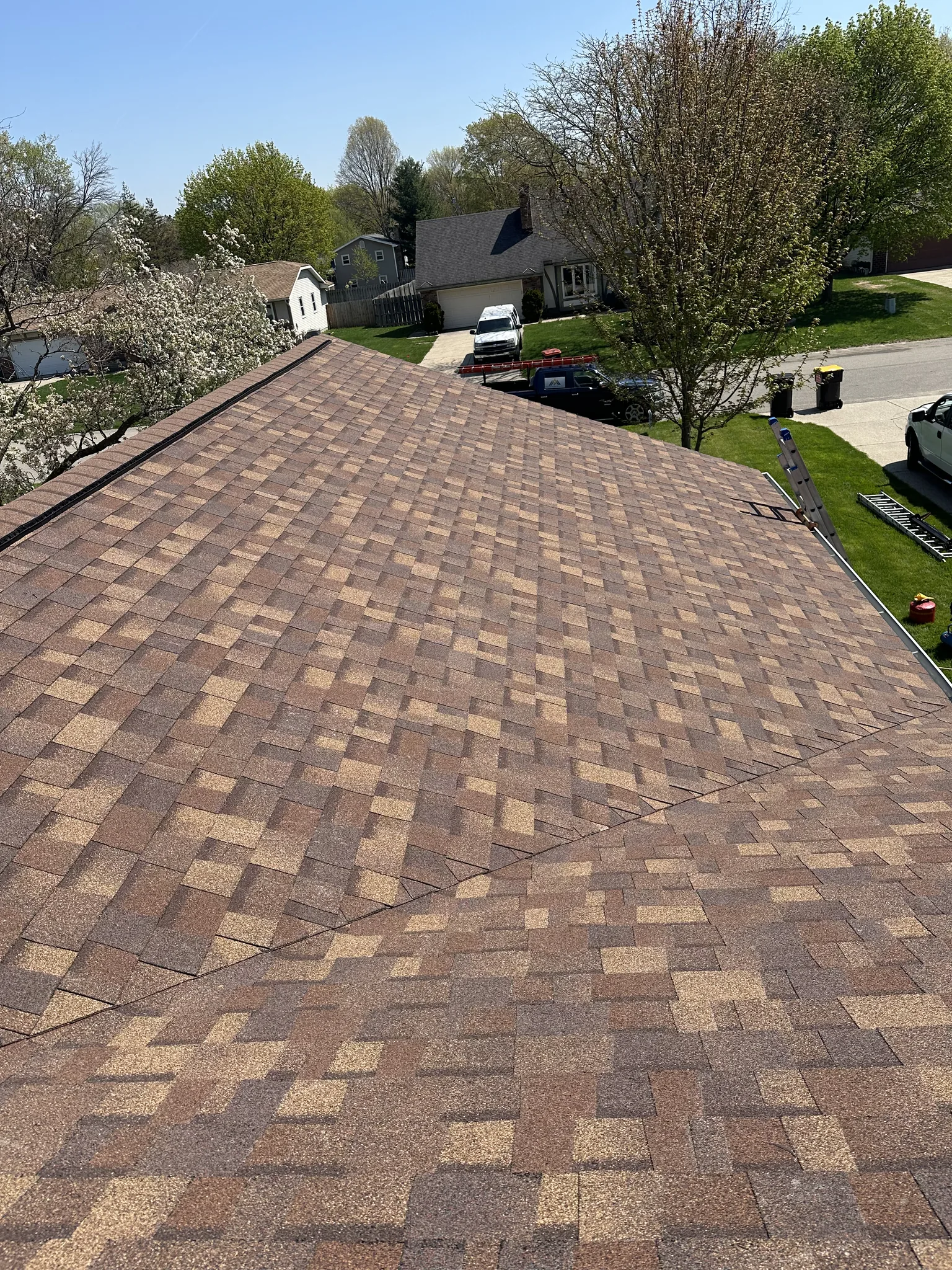Close-up of an aging asphalt shingle roof losing granules — the slow storm damage that surfaces months after the date of loss, as the Michigan claim window counts down